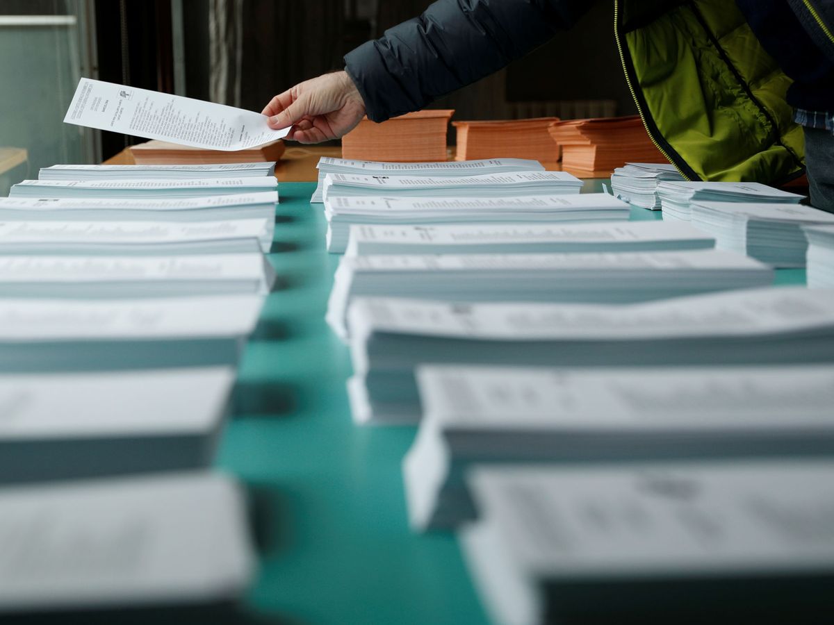 Foto: Un hombre coge una papeleta durante las elecciones generales. (Reuters)