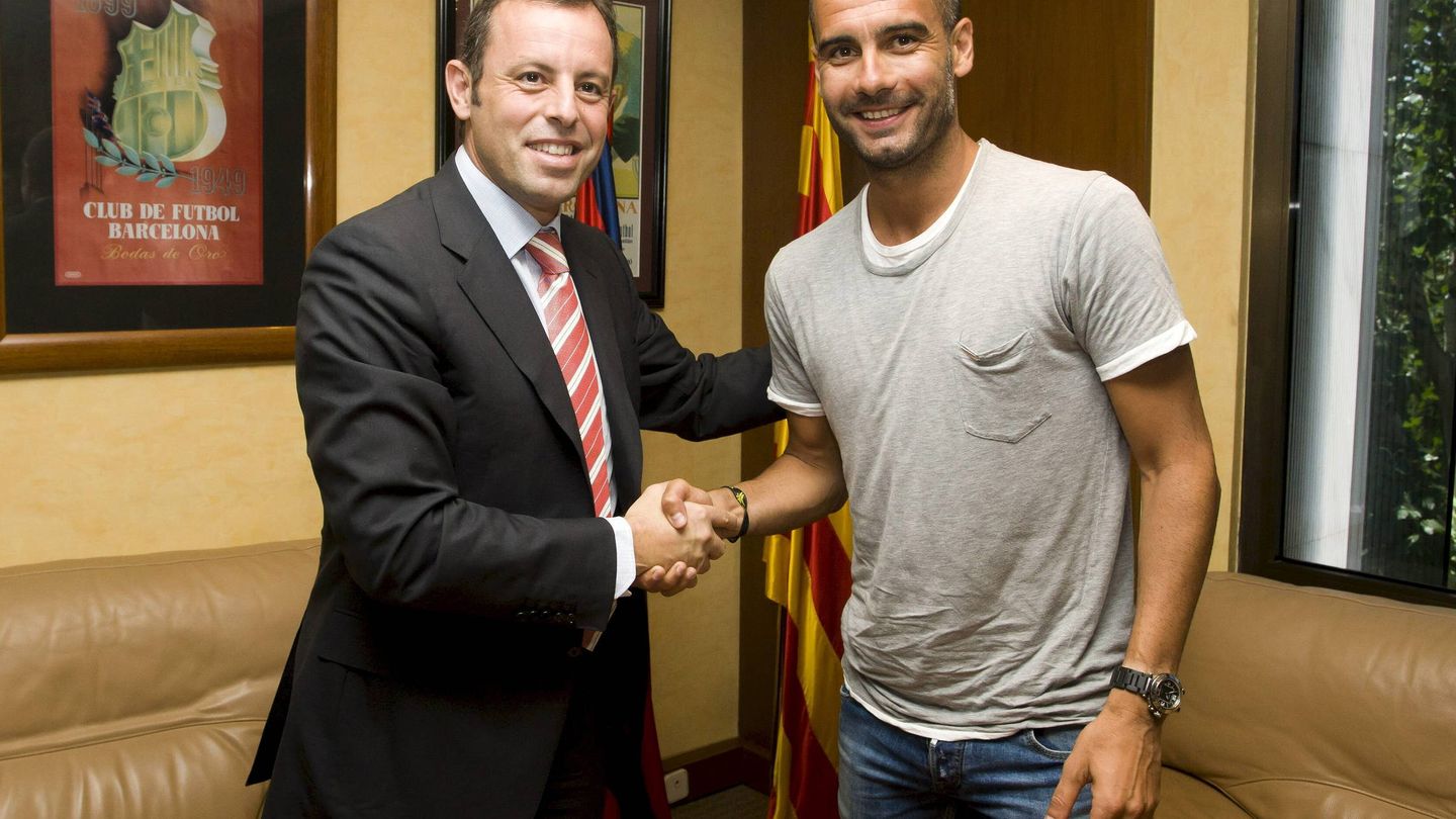 Pep Guardiola estrecha la mano de Sandro Rosell tras renovar su contrato con el Barça hasta junio de 2011. (EFE)