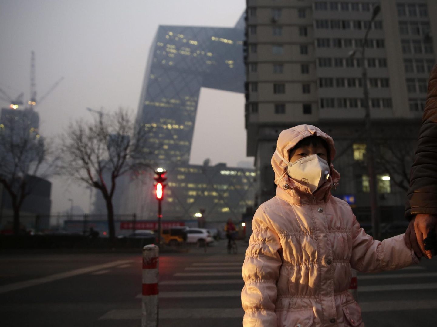  Una niña usa una mascarilla para protegerse de la contaminación ambiental en Pekín. Foto: EFE/HOW HWEE YOUNG
