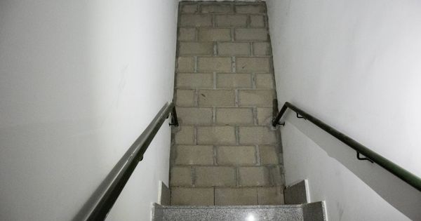 Foto: Un muro en mitad de una escalera comunitaria para aislar a okupas. (D. B.)