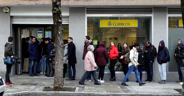 Foto: Decenas de personas hacen cola este jueves en una oficina de Correos de Madrid. (EFE)