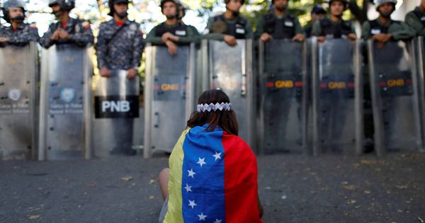 Foto: Una niña ante efectivos de seguridad venezolanos durante una protesta opositora en Caracas. (Reuters)