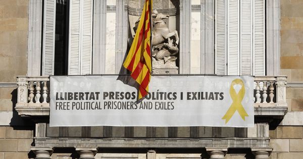 Foto: Vista del cartel reclamando la libertad de los líderes independentistas presos y un lazo amarillo en la fachada del Palau de la Generalitat, este martes. (EFE)