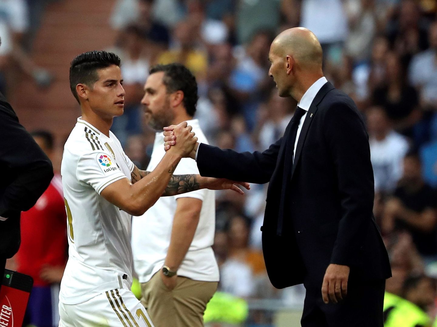 James y Zidane chocan sus manos en el partido contra el Valladolid. (Efe)