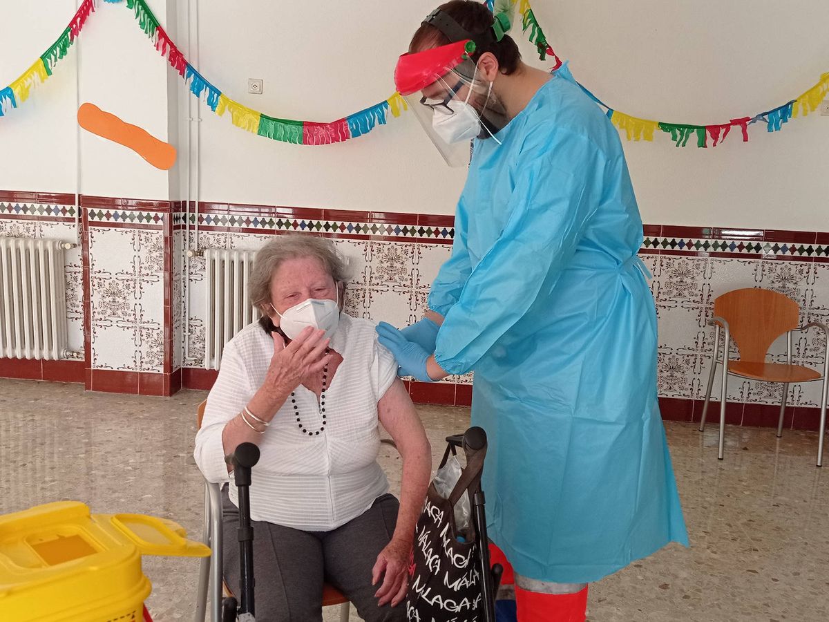 Foto: Eugenia, de 88 años, en el momento de recibir la vacuna del covid 19 en la residencia de ancianos de El Palo, en Málaga.