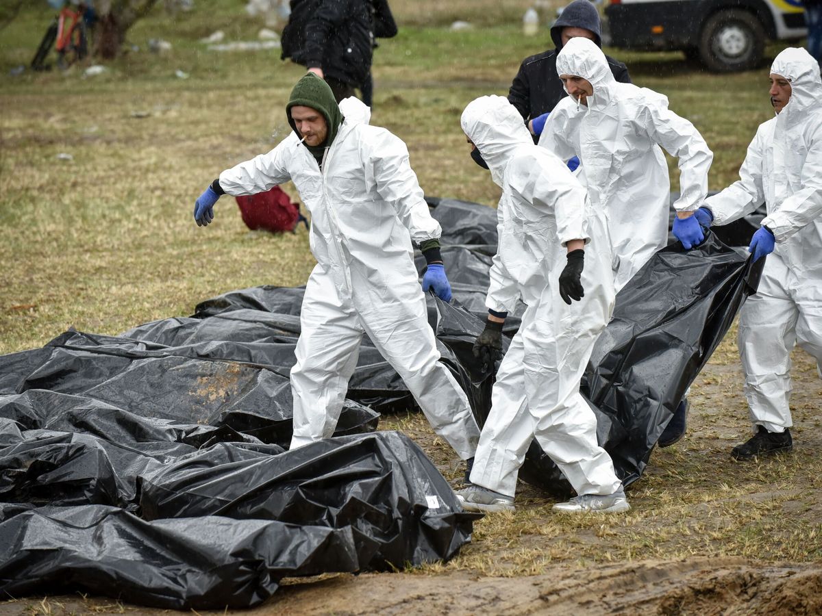 Foto: Agentes de la policía forense de ucrania exhuman los cuerpos de las fosas comunes encontradas en Bucha. (EFE / Oleg Petrasyuk) 
