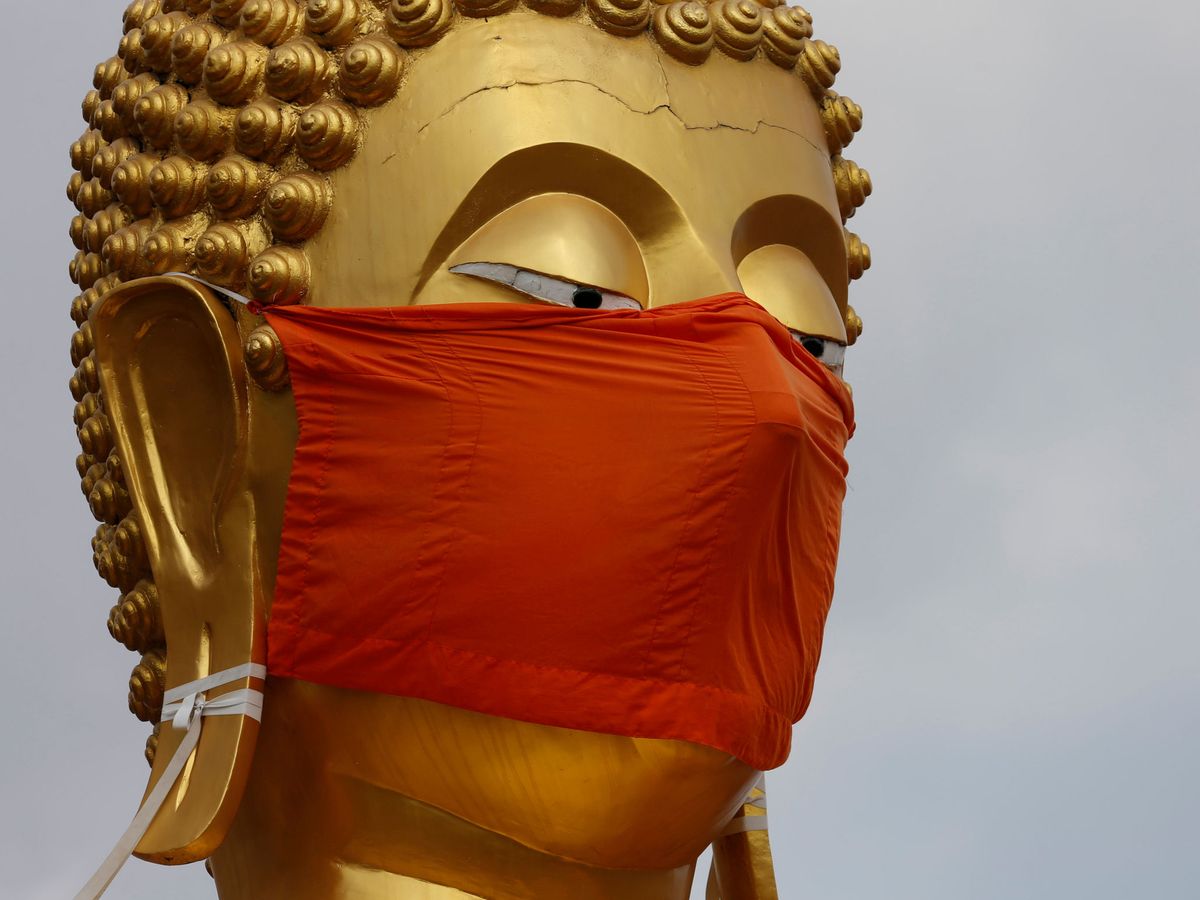 Foto: Una estatua de Buda con mascarilla en Tailandia. (Reuters)