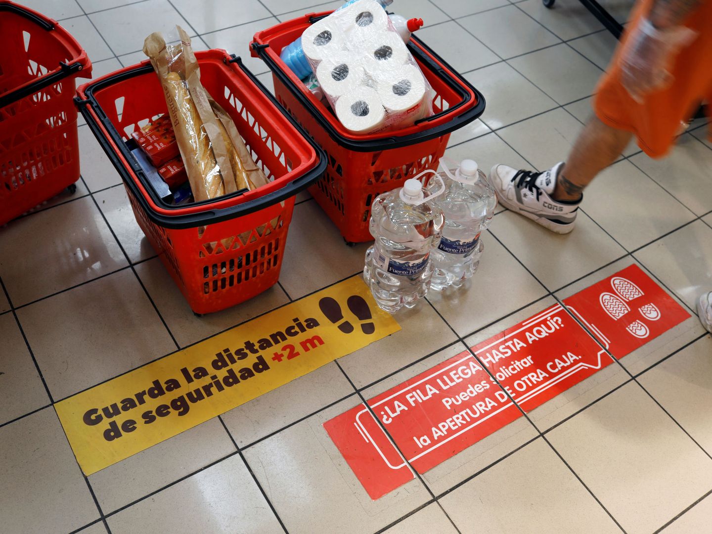 Un supermercado recuerda que se guarde la distancia de seguridad en caja (REUTERS)