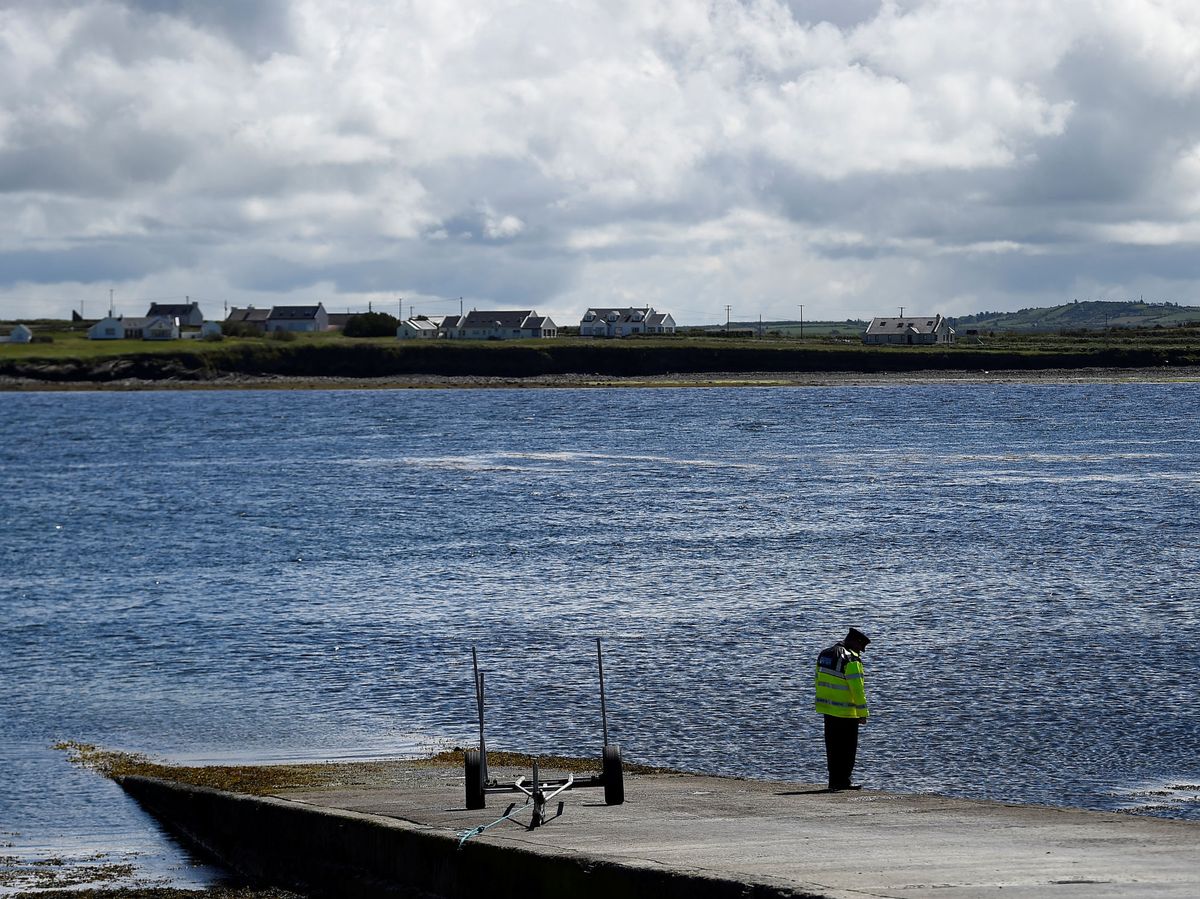 Foto: Un agente de la policía irlandesa (Garda Siochana) vigila un muelle con vistas a la costa. (Reuters) 