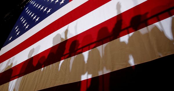 Foto: Las sombras de partidarios de Donald Trump se proyectan sobre la bandera estadounidense durante un acto en Las Vegas, el 20 de septiembre de 2018. (Reuters)