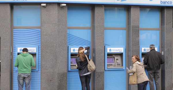 Foto: Fotografía de archivo de una sucursal bancaria en Santiago de Compostela, donde varios usuarios retiran dinero del cajero. (EFE)