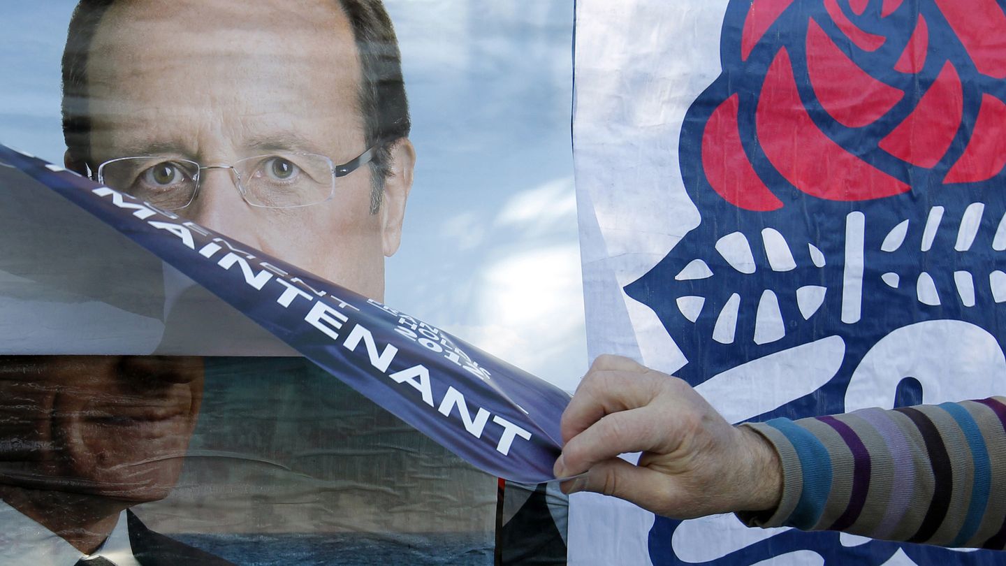 Un militante del Partido Socialista pega un póster de Hollande sobre otro de Sarkozy en Nantes (Reuters).