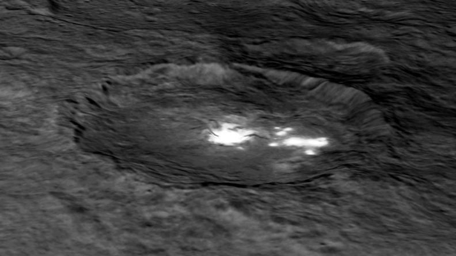 Foto: Cráter Occator de Ceres, donde se observan varios puntos brillantes y otro cráter interior de unos diez kilómetros de diámetro y medio kilómetro de profundidad. / NASA / JPL-Caltech / UCLA / MPS / DLR / IDA