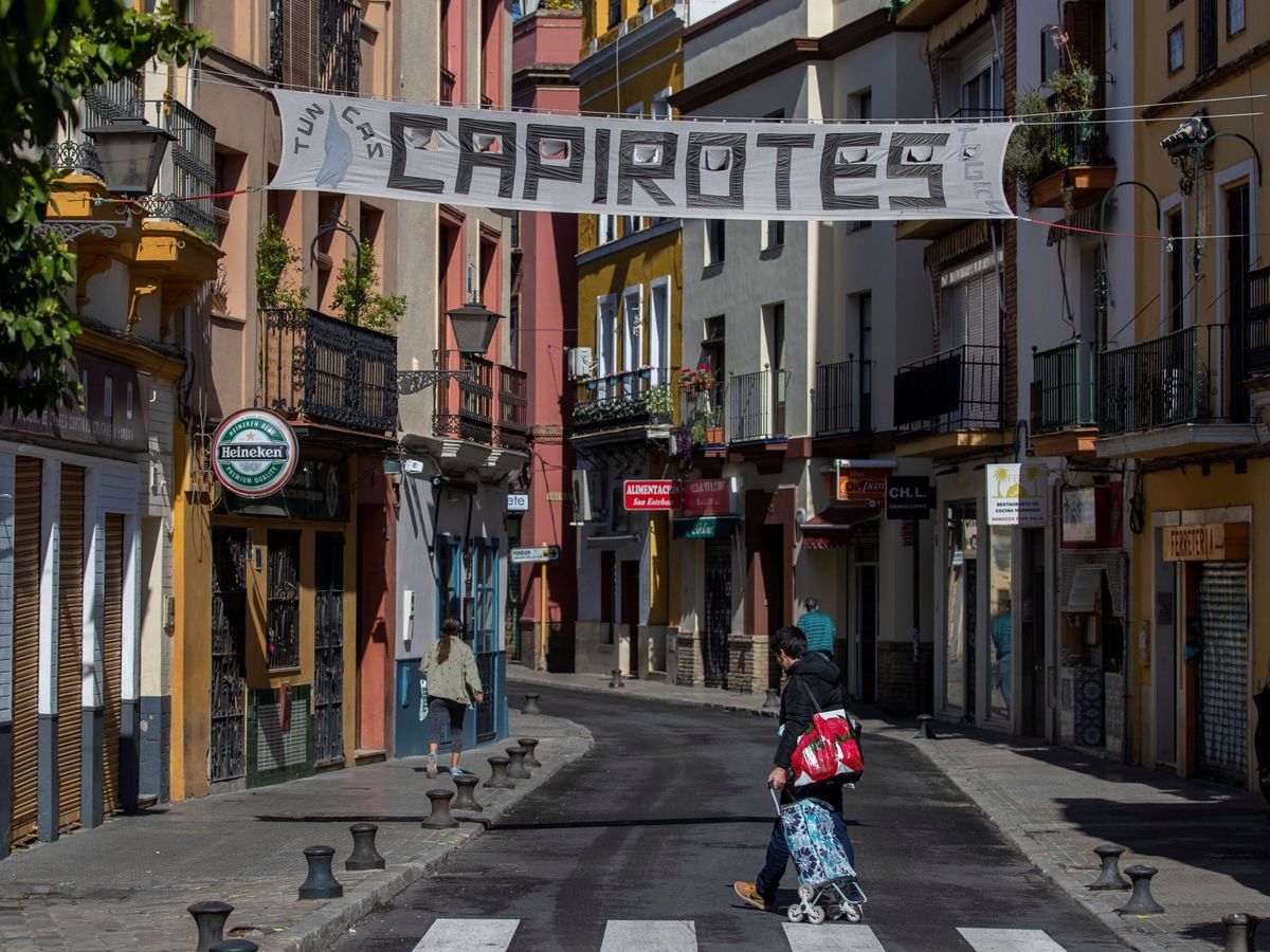 Foto: Un hombre camina bajo el cartel de un comercio de Sevilla que anuncia capirotes para la Semana Santa (EFE)