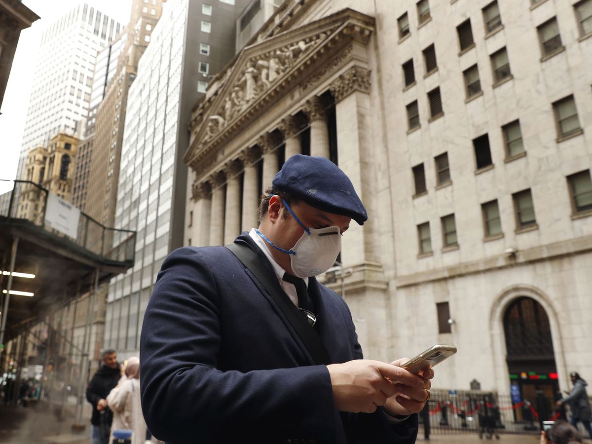Foto: Un hombre con mascarilla frente a la fachada de Wall Street. (Reuters)