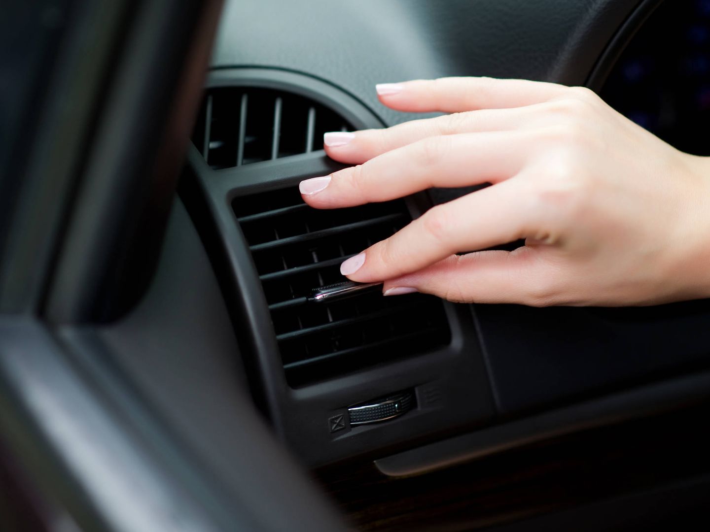 Una conductora ajusta el aire acondicionado de su coche. (iStock)