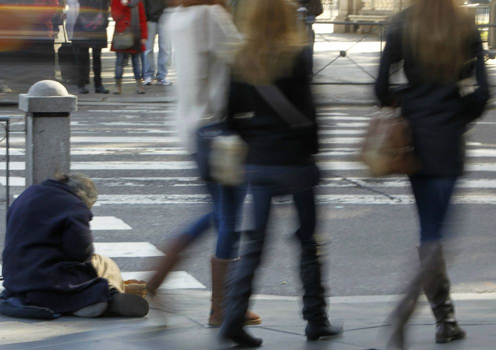 Foto: Un mendigo pide limosna ante la indiferencia de los transeuntes en la Plaza de Cibeles. (EFE)