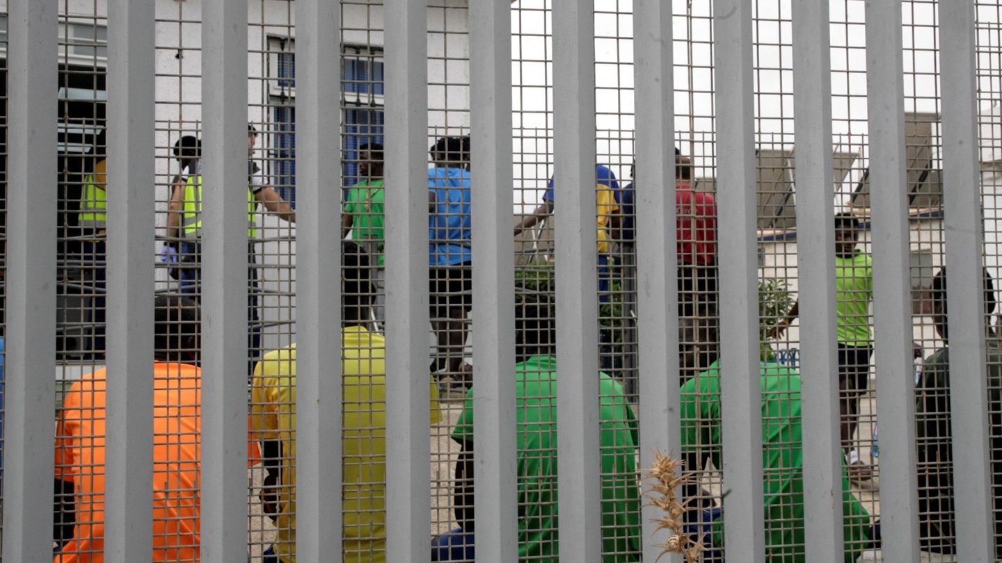 Un grupo de inmigrantes subsaharianos, tras el muro del Centro de Estancia Temporal de Inmigrantes (CETI), el pasado 19 de julio en Melilla. (EFE)