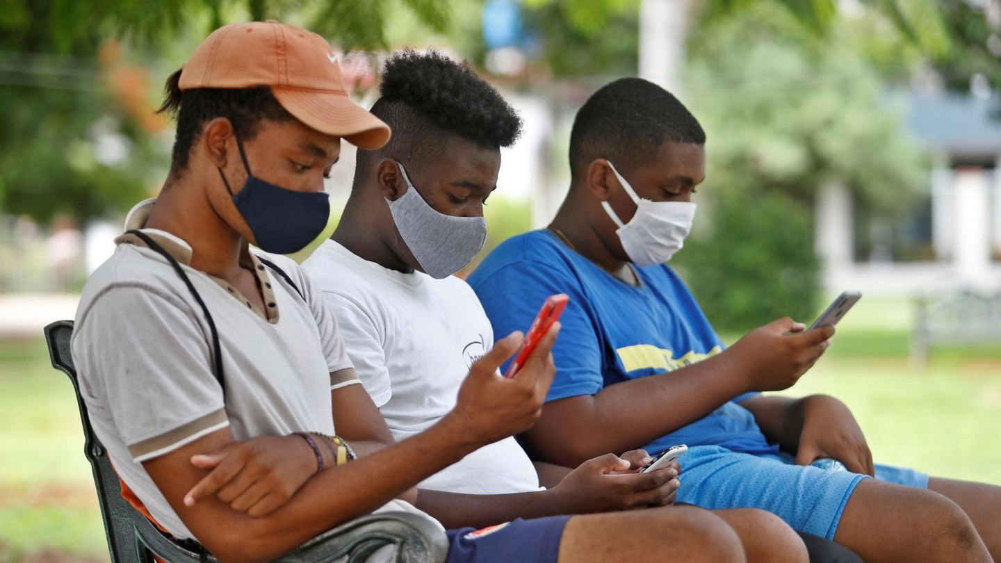 Jóvenes observan sus teléfonos en una zona wifi de La Habana. (EFE)