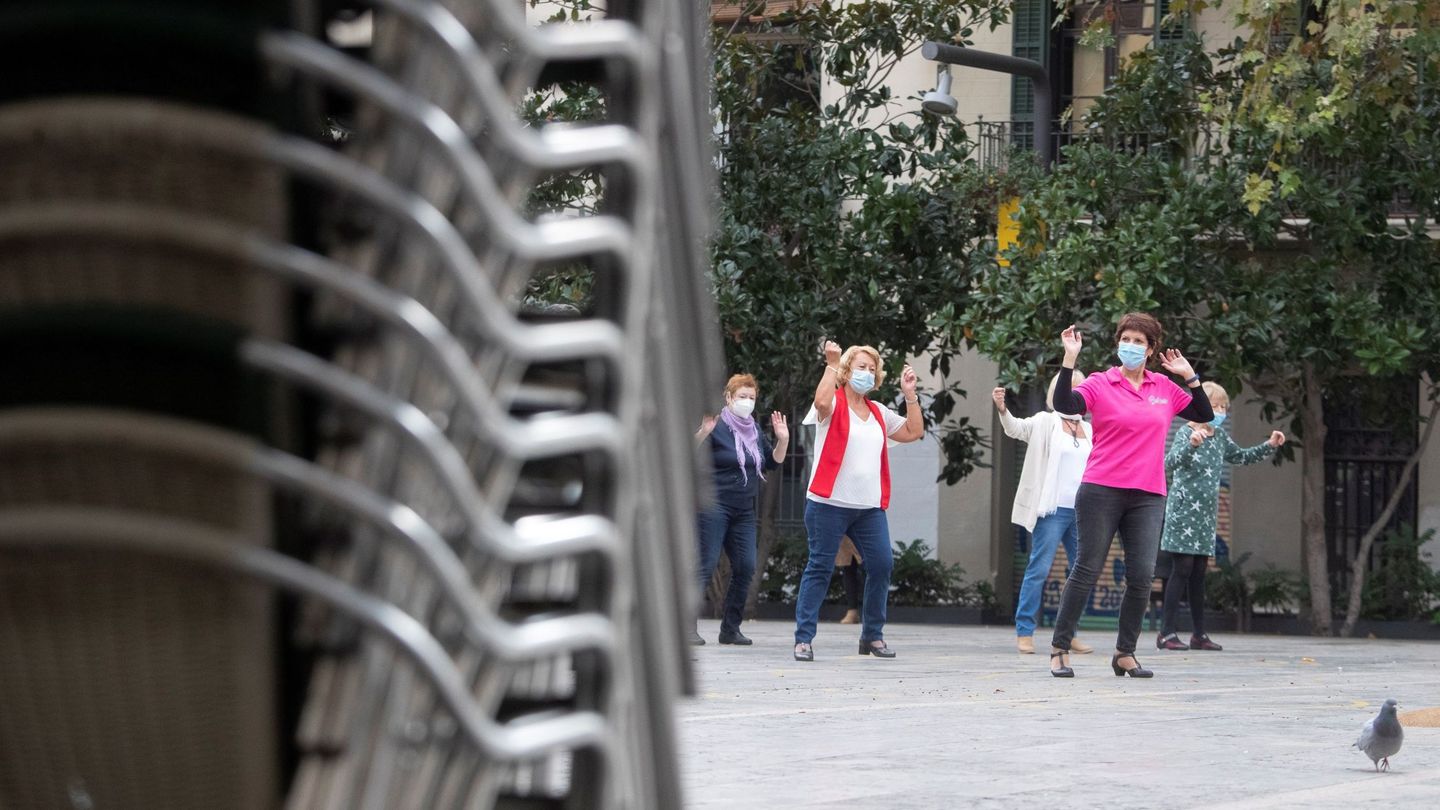 Varias mujeres hacen ejercicio en una plaza del centro de Barcelona con las terrazas clausuradas. (EFE)