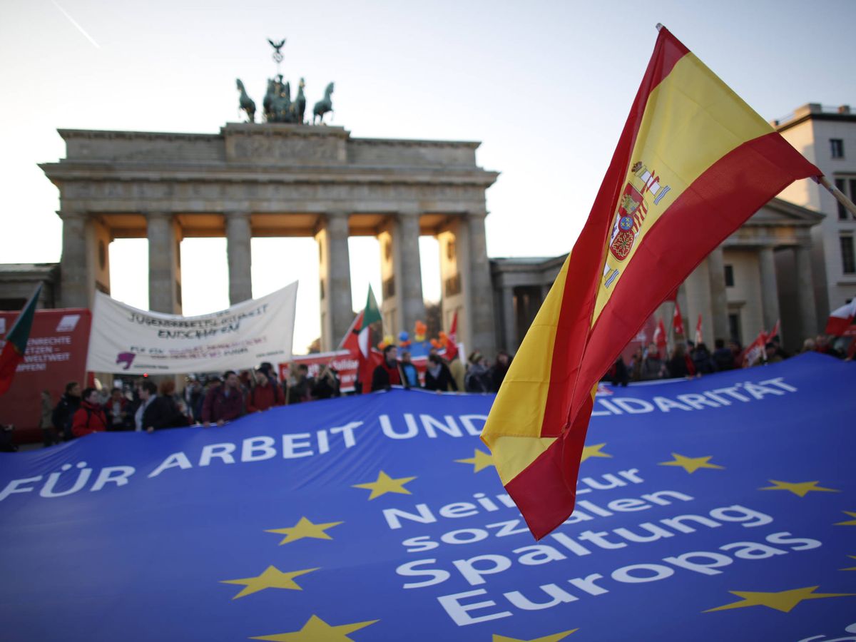 Foto: Una bandera de España es ondeada durante una protesta frente a la puerta de Brandenburgo, en Berlín. (Reuters)