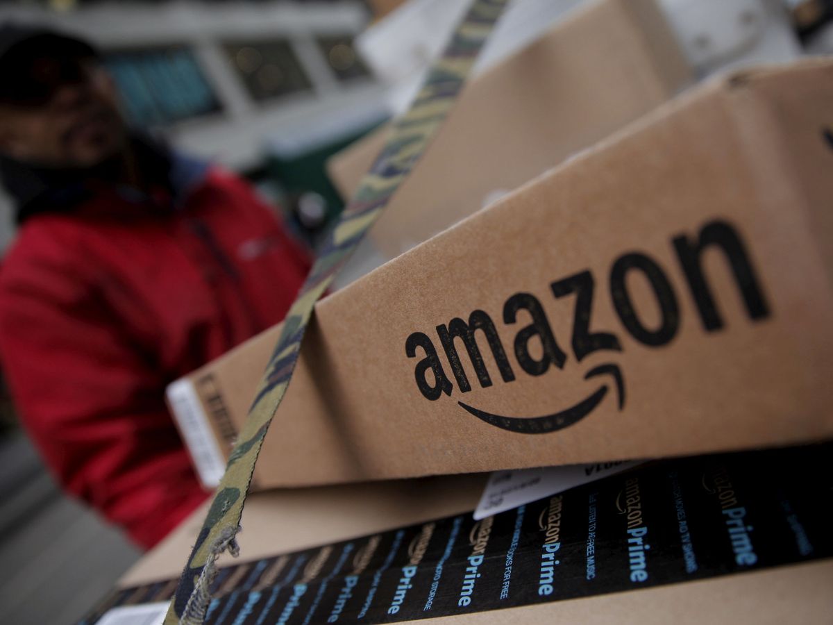 Foto: Un trabajador reparte paquetes de Amazon. (Reuters)