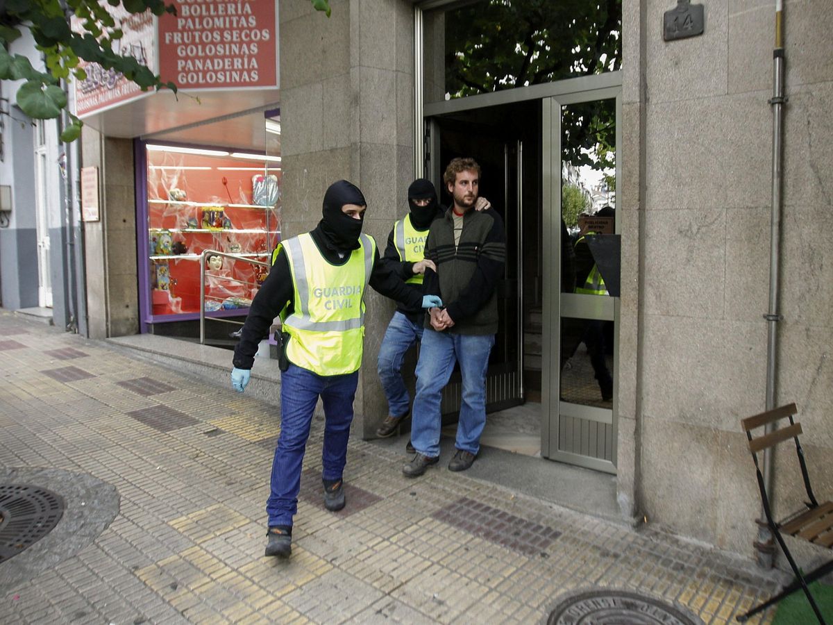 Foto: Dos agentes de la Guardia Civil trasladan a un hombre detenido en Ourense, en 2015, en el marco de la operación Jaro. (EFE)