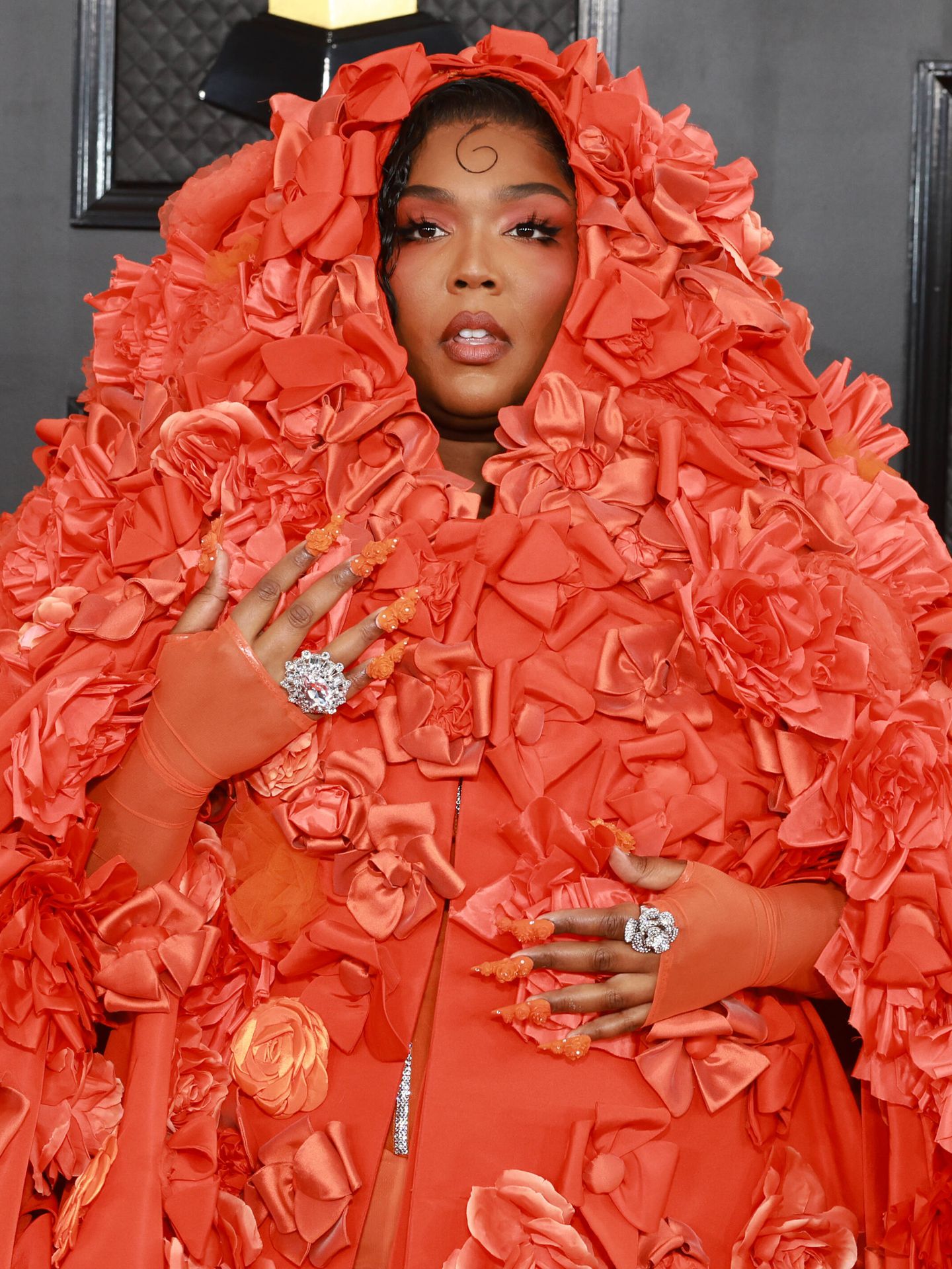 Lizzo, cubierta por la capa de Dolce & Gabbana con su maquillaje 'total orange' a su llegada a los Grammy. (Getty/Matt Winkelmeyer)
