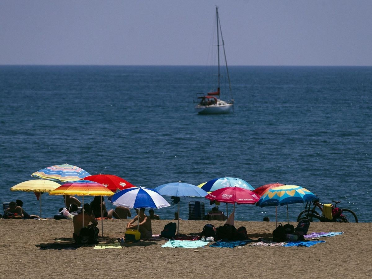 Foto: Bañistas bajo las sombrillas en la playa de La Malagueta. (EFE/Jorge Zapata)