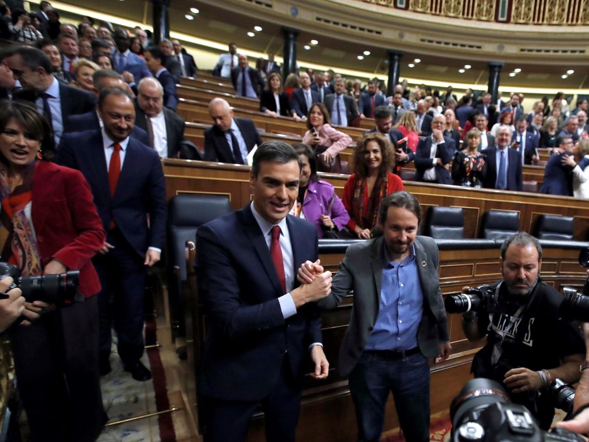 Foto: Pedro Sánchez es felicitado por Pablo Iglesias tras conseguir ser investido por 167 votos a favor, este 7 de enero en el Congreso. (EFE)