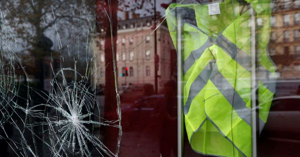 Foto: Un chaleco amarillo colgado tras una vitrina rota en una tienda en París, el 2 de diciembre de 2018. (Reuters)