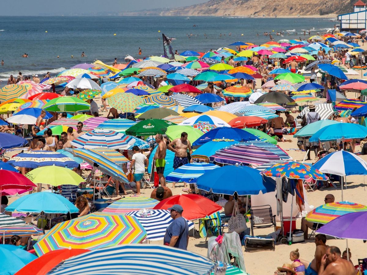 Foto: Sombrillas y bañistas abarrotan la playa de Matalascañas. (EFE/Julián Pérez)