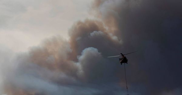 Foto: Un helicóptero en labores de extinción en las inmediaciones de la localidad de Bovera, en Tarragona. (EFE)