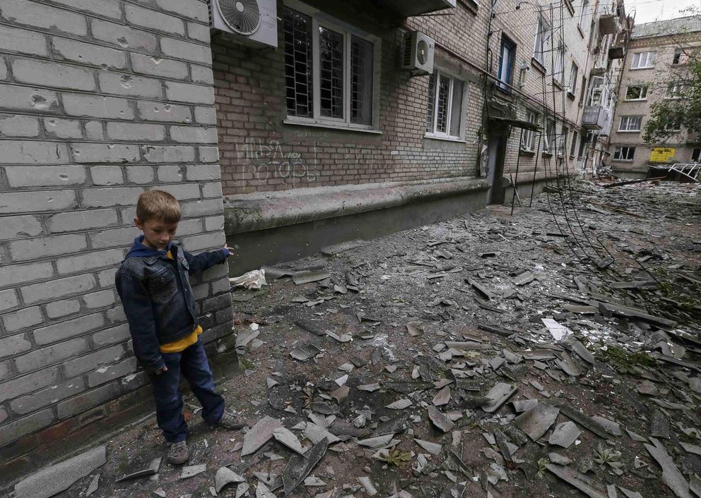 Un niño juega junto a un edificio residencial dañado por los combates en Slaviansk (Reuters). 