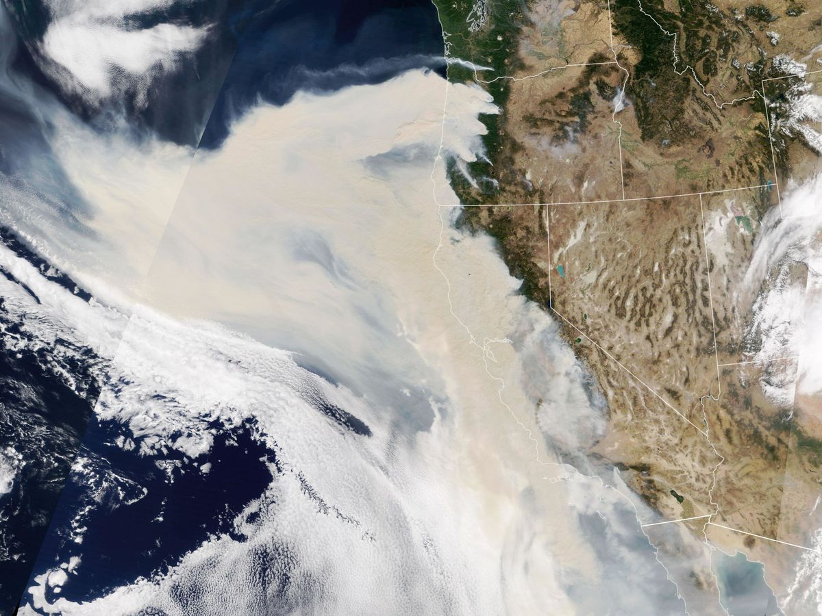 Foto:  Fotografía cedida por la NASA donde aparece un espeso humo que fluye desde de una línea de incendios intensos en Oregón y California. (EFE)