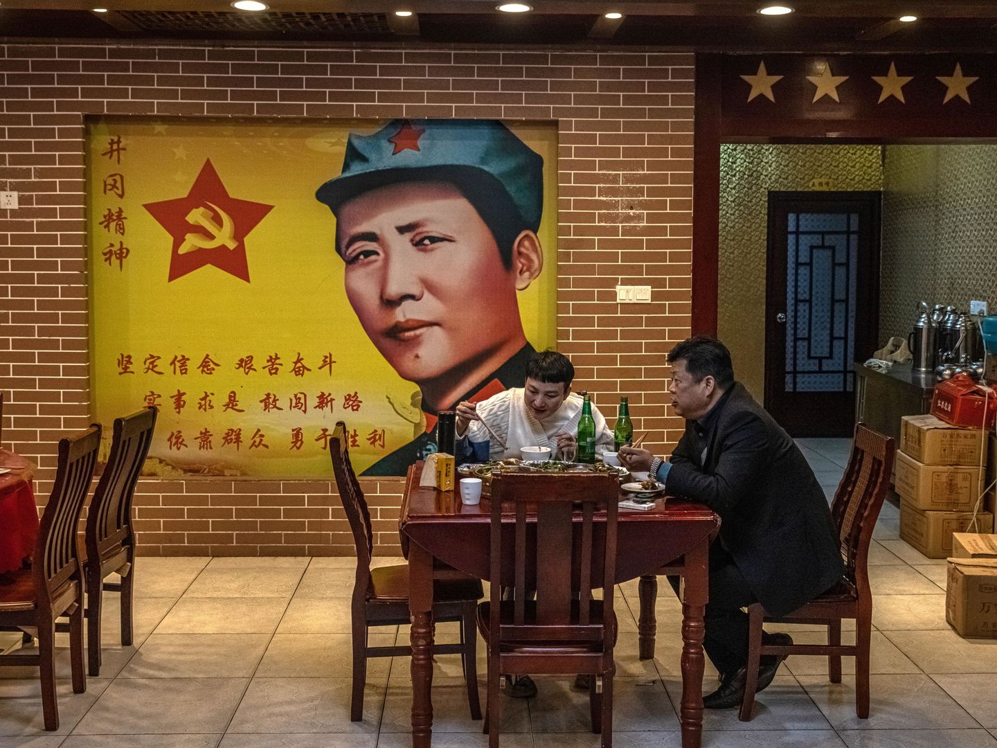 Gente comiendo en un restaurante bajo la imagen de Mao Tse-tung en la provincia china de Jiangxi (EFE)