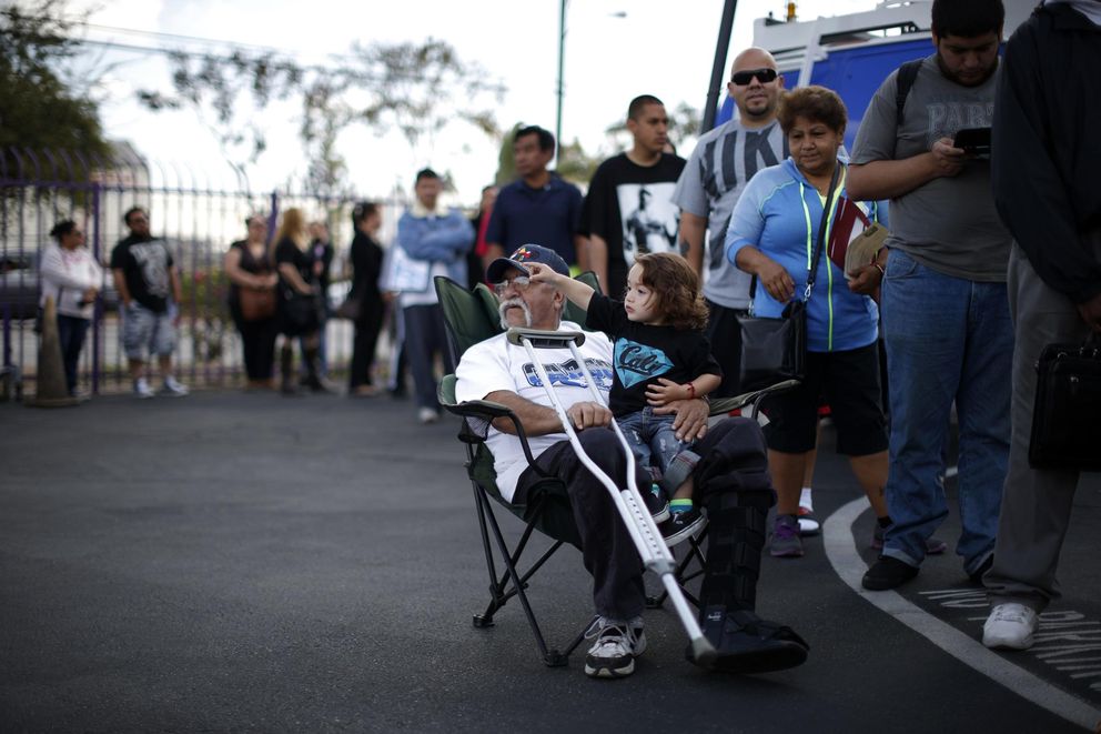 Juan Ortiz, 67, y su nieto en una cola para inscribirse en un seguro sanitario en Commerce, California (Reuters).