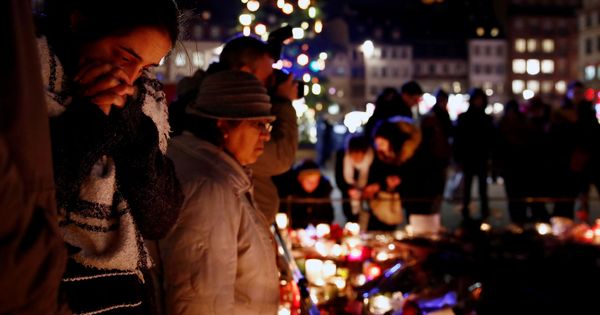 Foto: Un grupo de personas llora mientras deposita flores y velas por las víctimas en Estrasburgo. (Reuters)