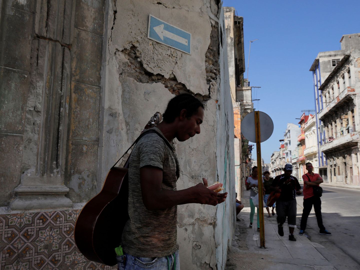 Un músico se come un perrito caliente en una calle de La Habana, en agosto de 2018. (Reuters)