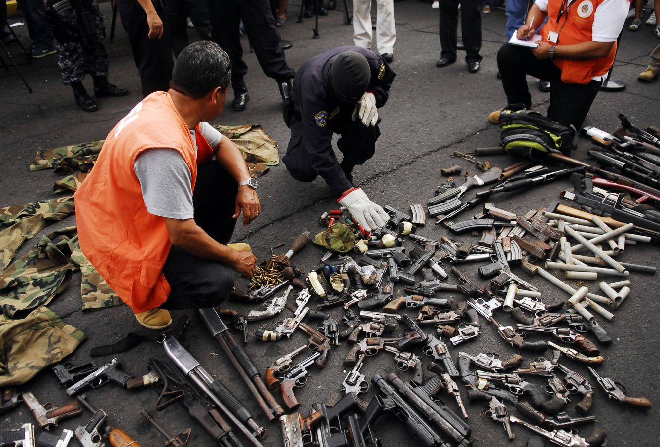 Funcionarios de la OEA recogen armas entregadas por miembros de las maras durante una tregua en 2013. (Reuters)
