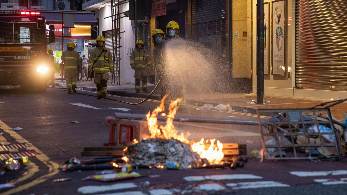Los bomberos sofocan una pequeña barricada tras las protestas de hoy en Hong Kong. (EFE)