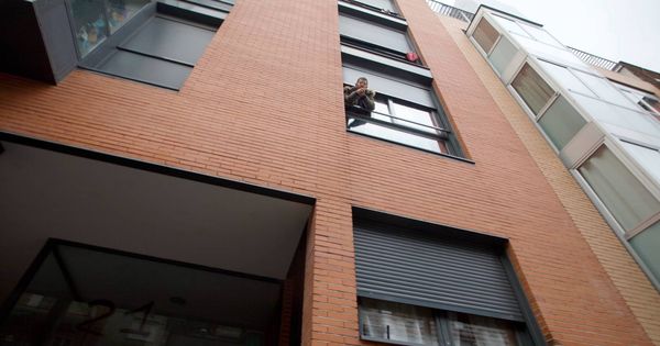 Foto: Un okupa se asoma a la ventana de un piso en Madrid. (Enrique Villarino)