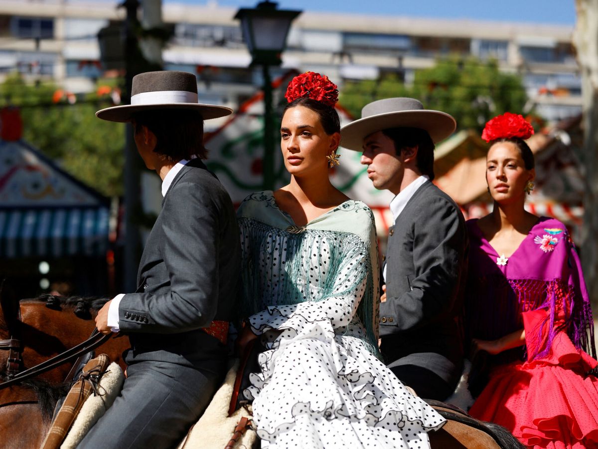 Foto: Un jinete con una mujer vestida de flamenca en la Feria de Sevilla de 2023. (Reuters/Marcelo del Pozo)