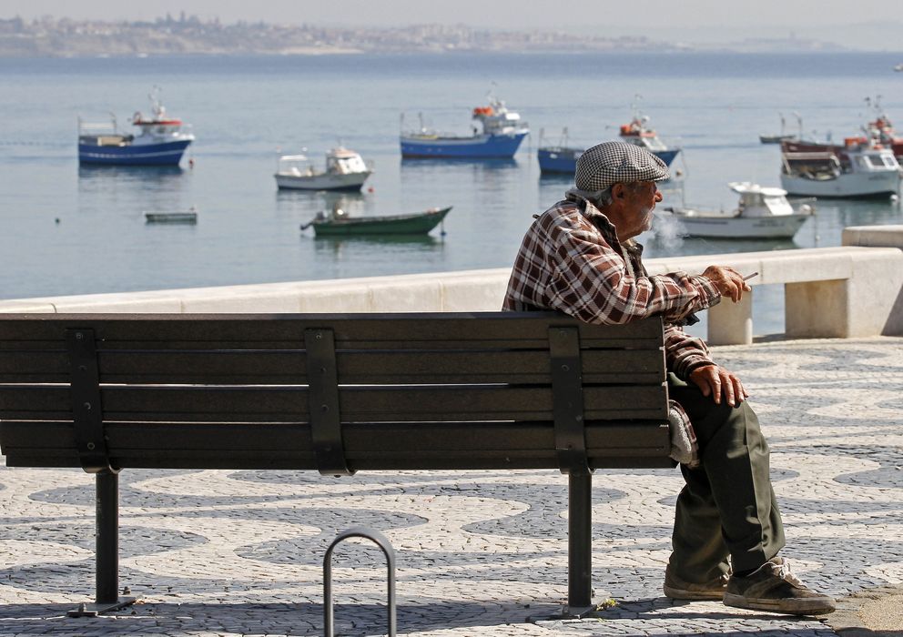 Foto: Un jubilado portugués fuma un cigarro sentado frente a la bahía de Cascais, un día de marzo de 2012. (Reuters)