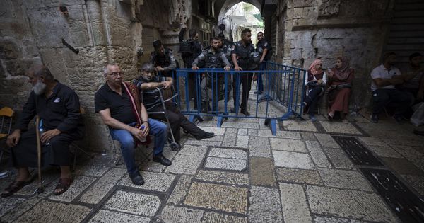 Foto: Varios palestinos esperan fuera de la Puerta de los Leones, el acceso principal al complejo en el que se encuentra la Mezquita de Al Aqsa en Jerusalén. (EFE)