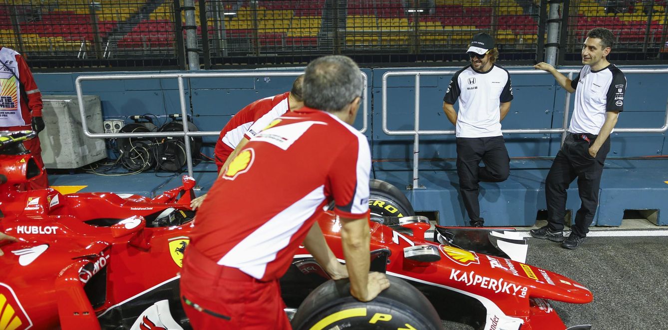 Alonso observa uno de los Ferrari en el circuito de Singapur (Efe)
