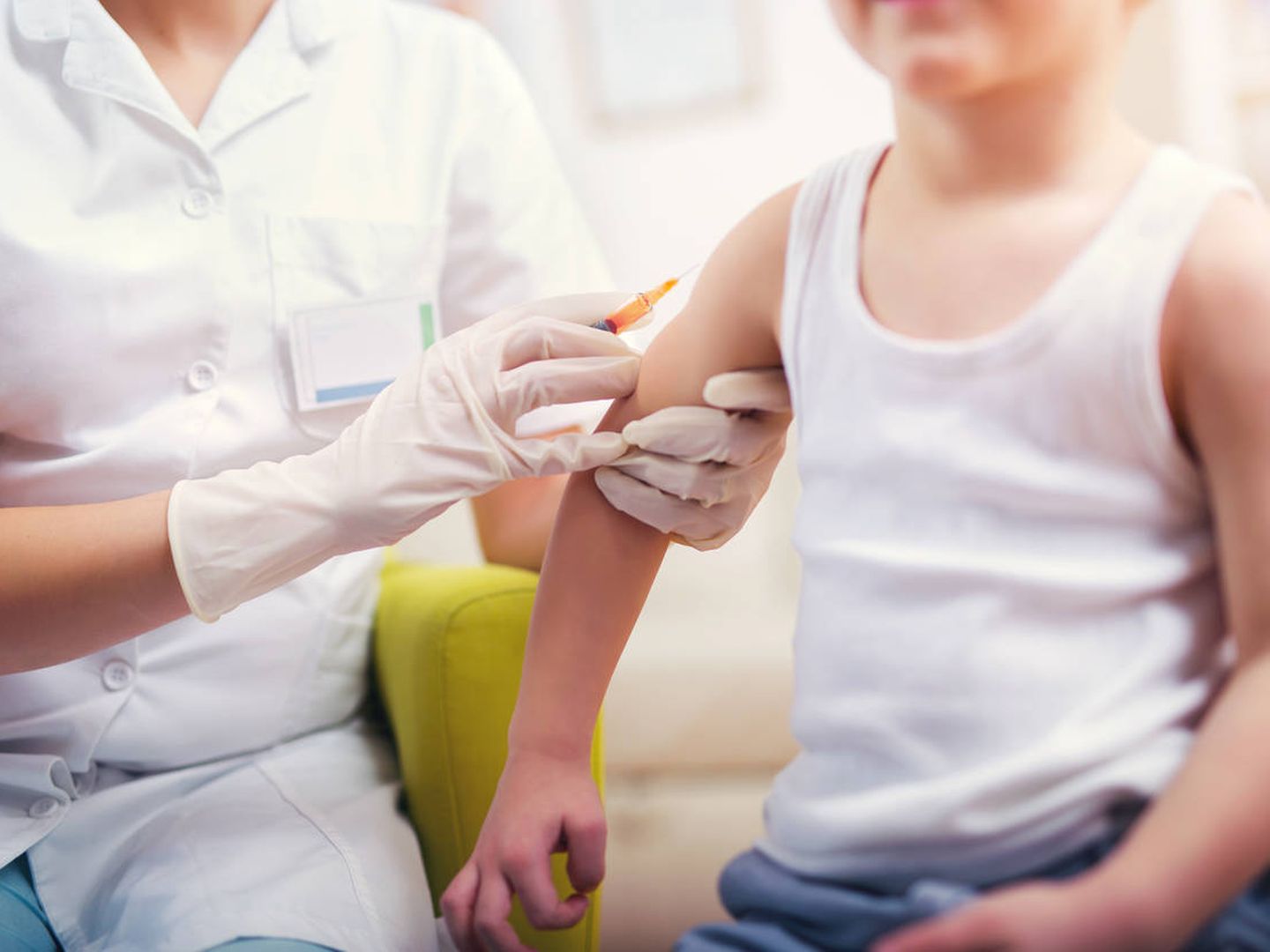Un pediatra suministra la vacuna de la gripe a un niño. (iStock)