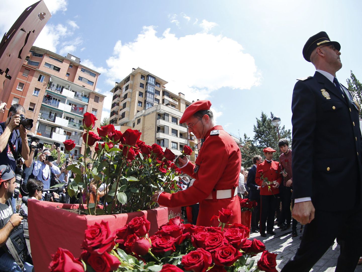 Un mando de la Ertzaintza junto a un miembro de la Policía Nacional pone una rosa para recordar el secuestro y asesinato del concejal del PP. (EFE)