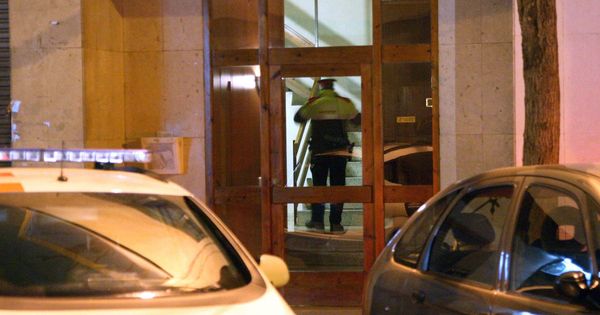 Foto: Un policía en el edificio donde se ha encontrado una mujer muerta con signos de violencia en Reus. (EFE)