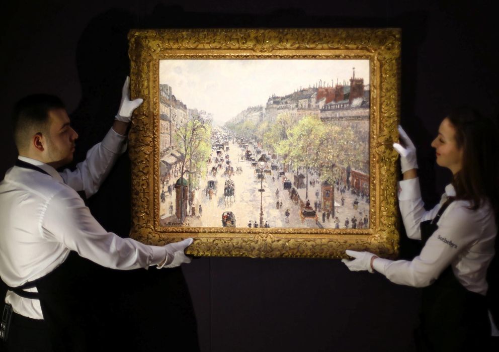 Foto: Unos empleados de Sotheby's sotienen la obra "Le Boulevard de Montmatre" (EFE)
